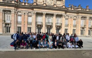 Pacientes renales posan frente a la fachada del palacio de la Granja de San Ildefonso durante la excursión organizada por el GAP