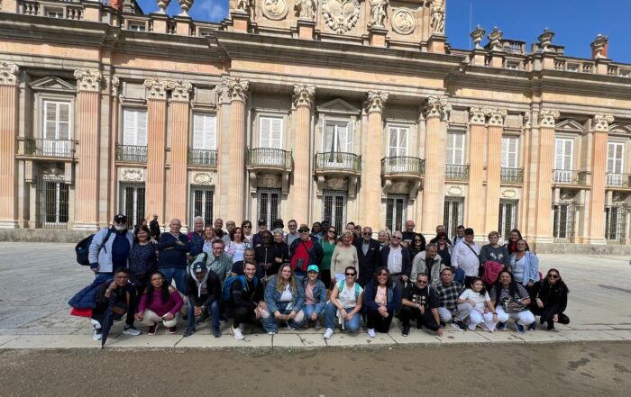 Pacientes renales posan frente a la fachada del palacio de la Granja de San Ildefonso durante la excursión organizada por el GAP